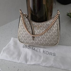 Michael Kors Jet Set Charm bag with logo and gold chain.